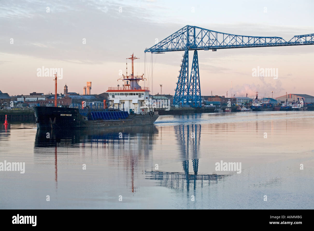 Ein Schiff verlässt den Hafen von Middlesbrough und unterquert die Schwebefähre über dem River Tees, North Yorkshire Stockfoto