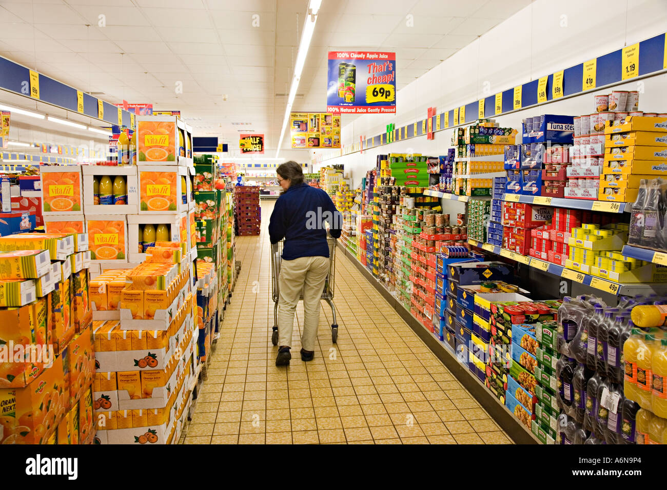 Weibliche Erwachsene schieben Einkaufswagen im Supermarkt Wales UK Stockfoto