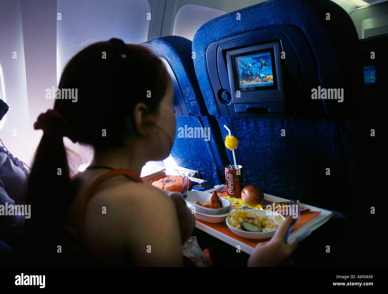 Kind an Bord Viedeo auf Airbus-Flugzeug, während des Essens Stockfoto