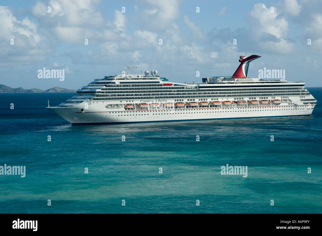 Die eleganten weißen Kontrast zu Carnival Cruise Ship, Liberty, das ruhige blaue Meer als es weg von der Insel Tortola Segel Stockfoto