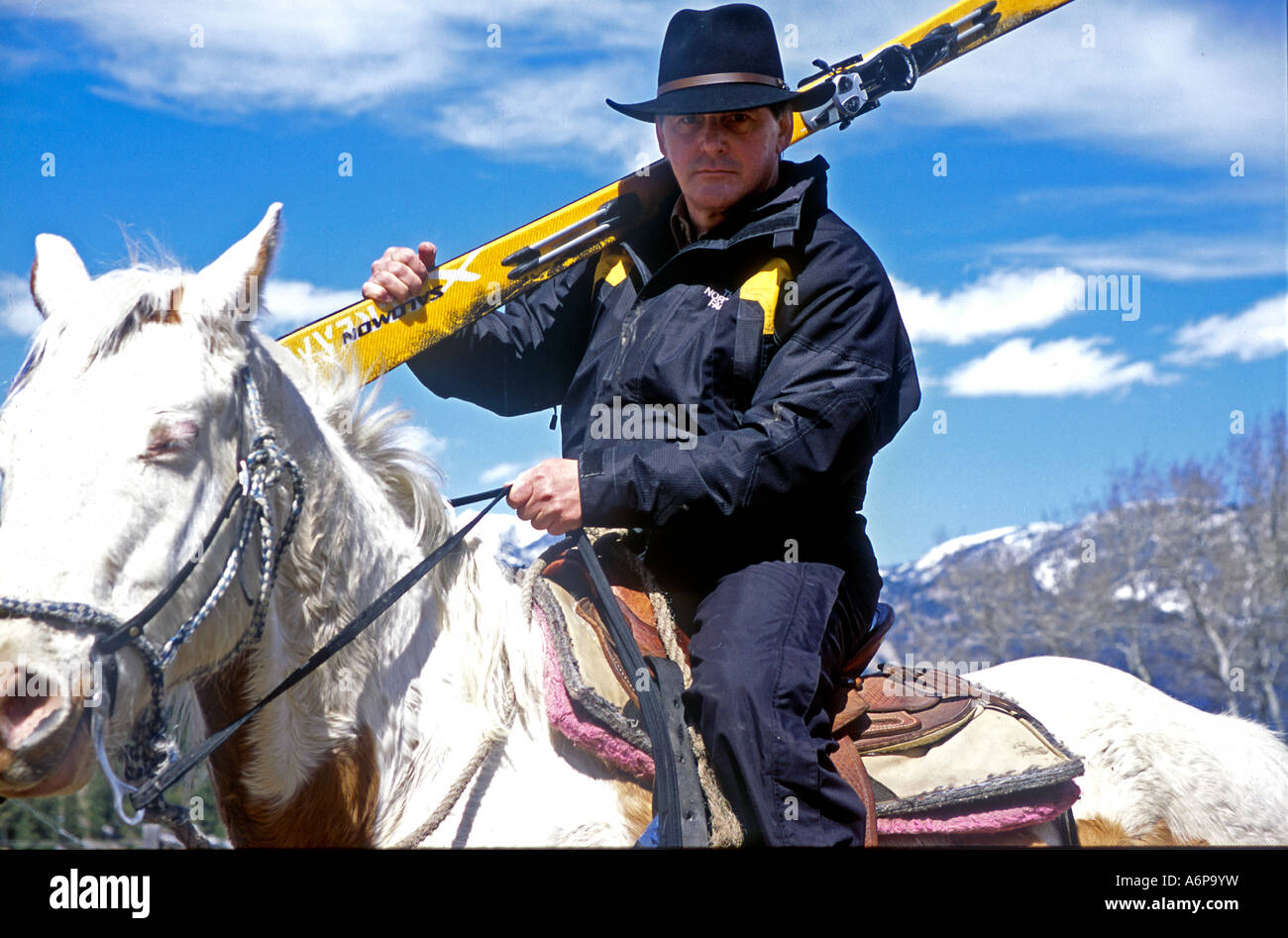 Mann trägt Cowboyhut, Reiten in den Bergen von Montana in der Nähe von Big Sky Ski Resort USA tragen seine Skier Stockfoto