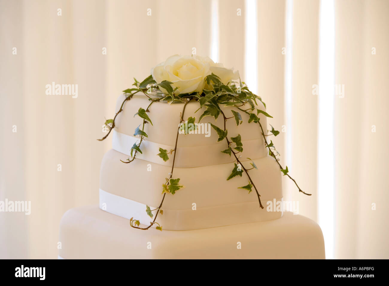 Hochzeitstorte, dekoriert mit Sahne-Rosen und Efeu Stockfotografie - Alamy