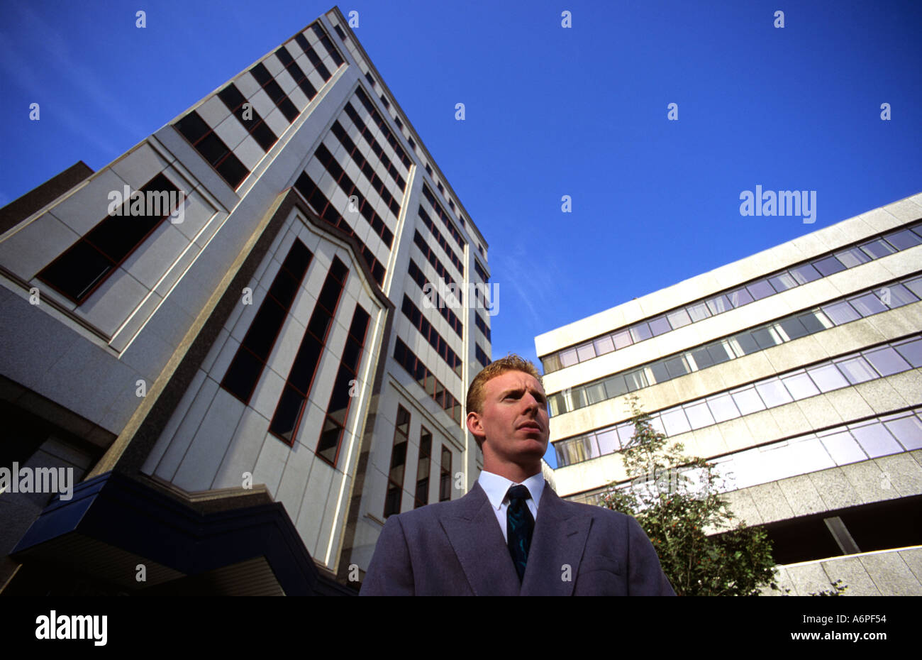 Geschäftsmann stand draußen Bürogebäude in der Stadt Leeds Yorkshire uk Stockfoto