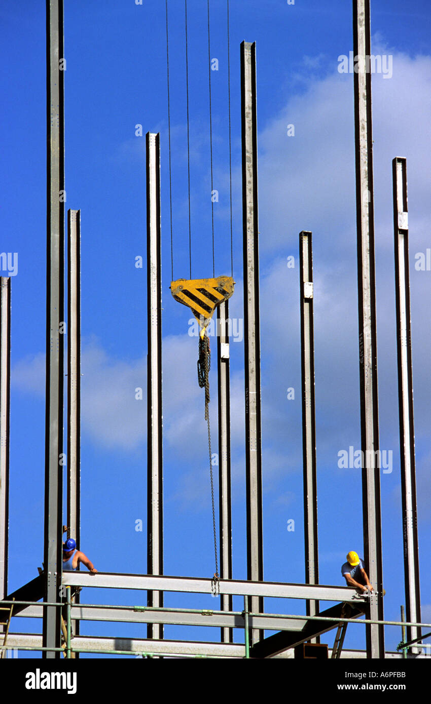 Bauarbeiter Befestigung Träger an Stahlgerüst während am Kran Winde auf der Baustelle in Leeds Großbritannien ausgesetzt Stockfoto