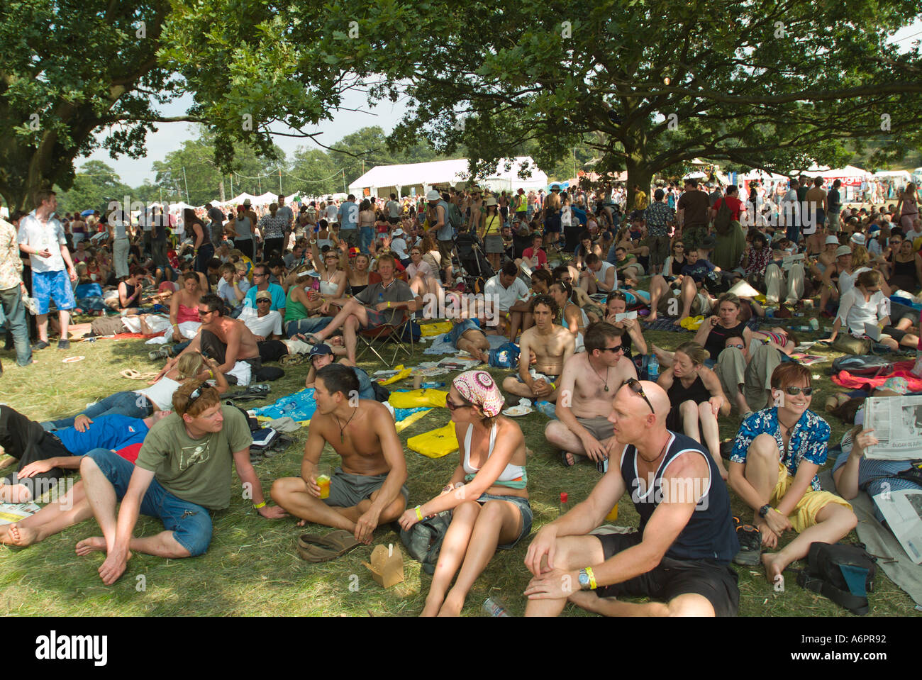 Festivalbesucher sitzen im Schatten unter einem großen Baum auf dem Big Chill Musik und Tanz-festival Stockfoto