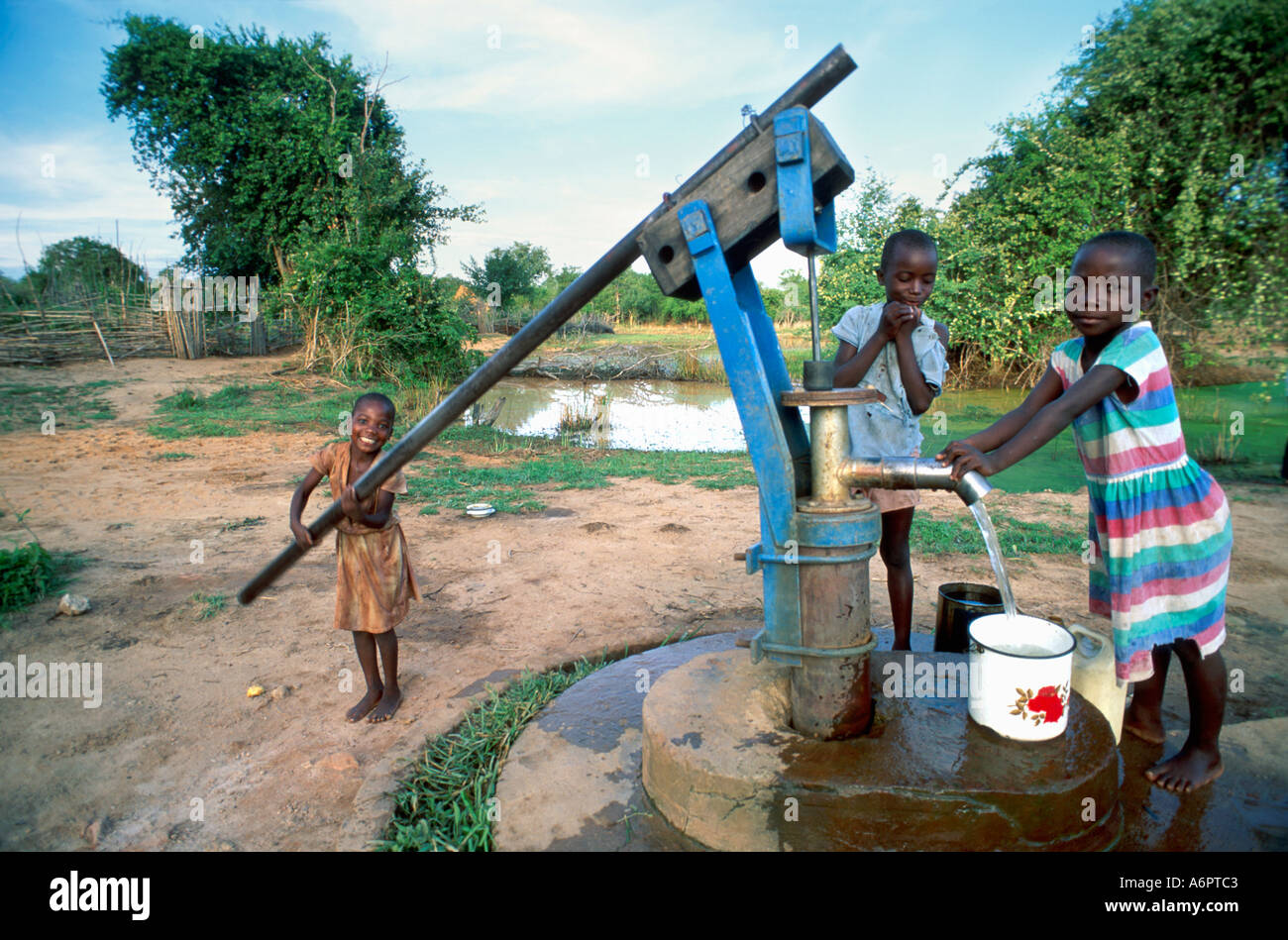 Junge Mädchen Pumpen Wasser aus dem Dorf Brunnen. Simbabwe Stockfoto