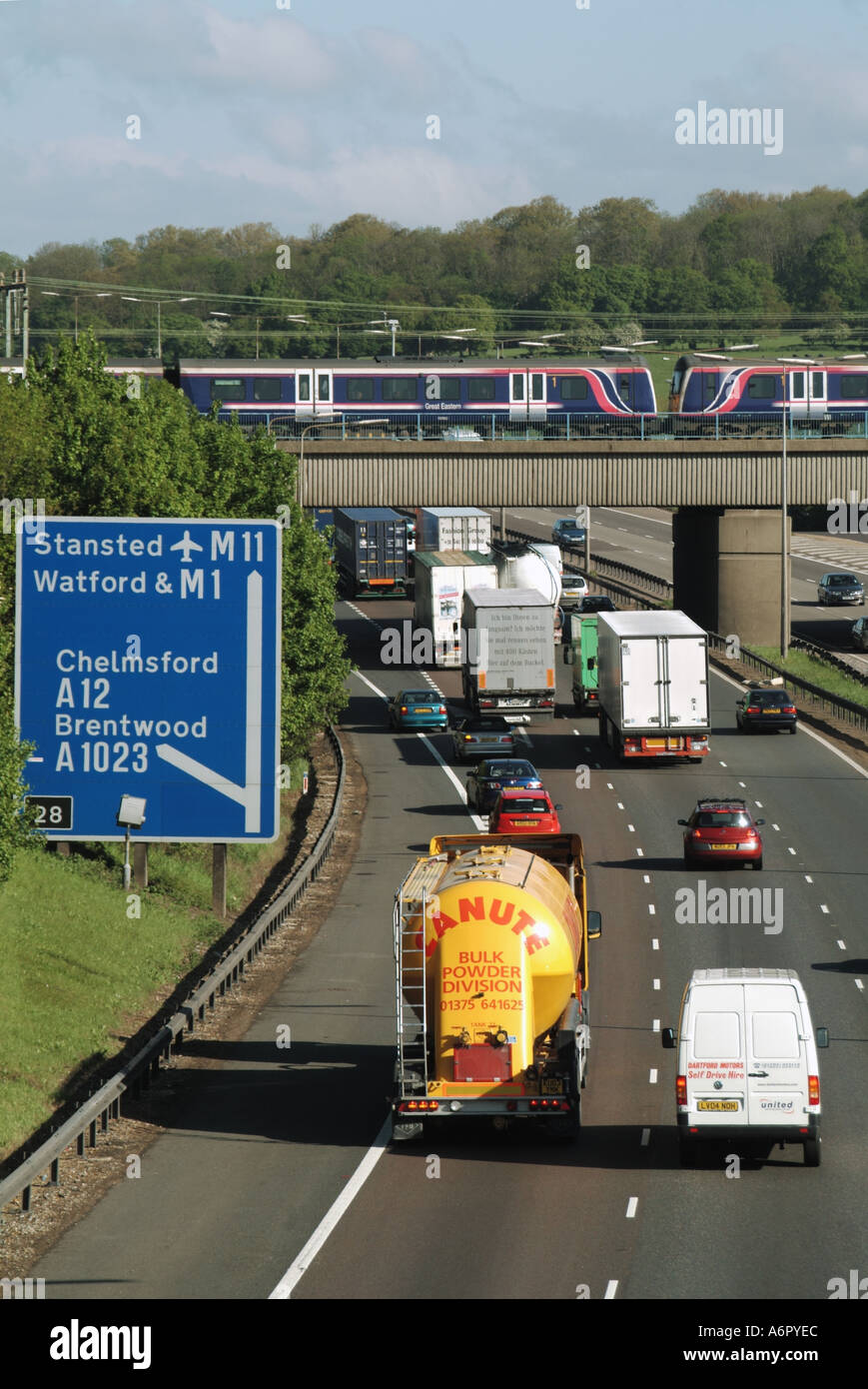 Verkehrsinfrastruktur Eisenbahnbrücke & schneller Personenzug Überquerung über dem Straßenverkehr an der Kreuzung 28 M25 Autobahn Brentwood Essex England UK Stockfoto