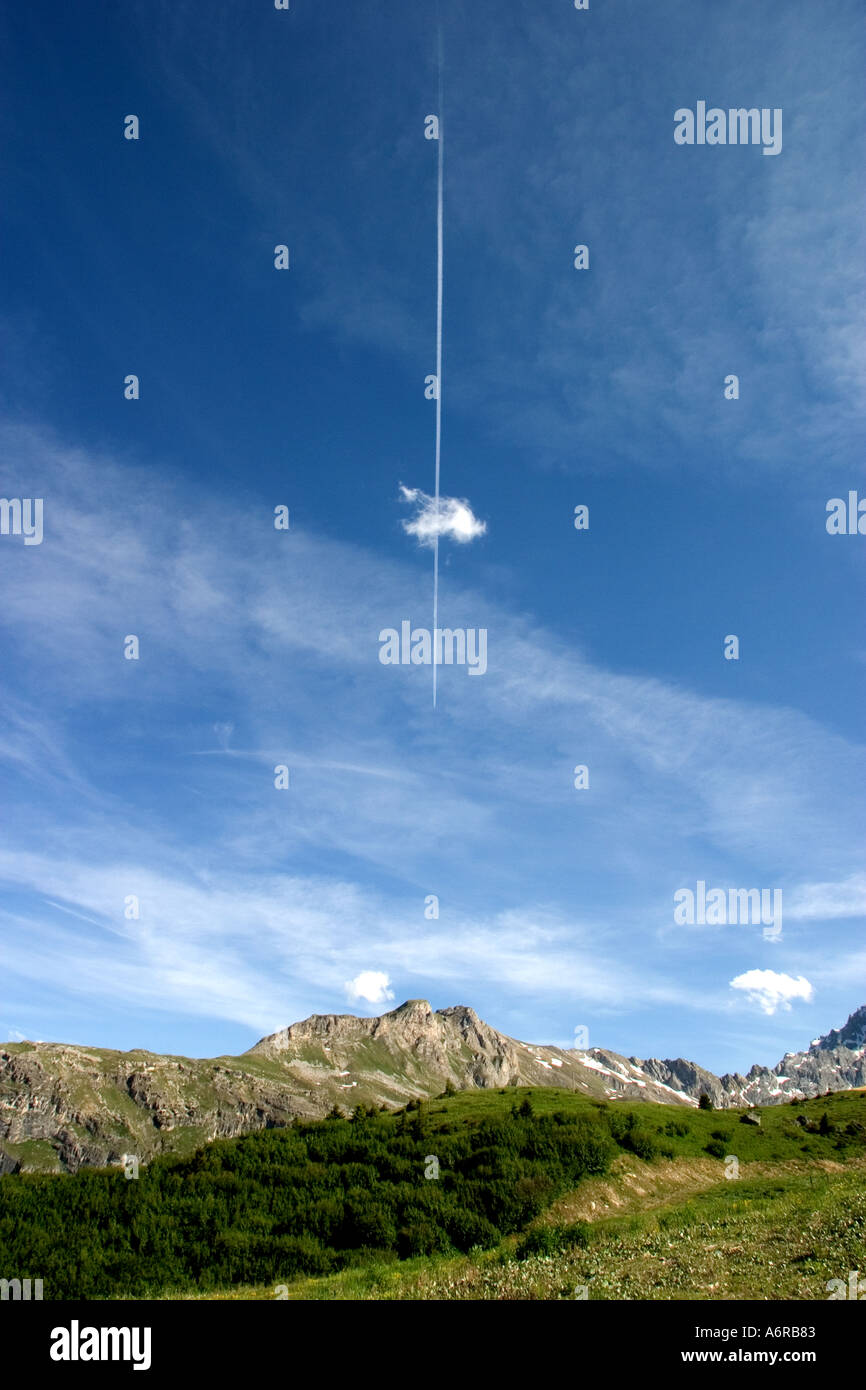 Flugzeug und Kondensstreifen fliegen durch eine Wolke hoch über die Alpen in Courchevel Trois Vallees Frankreich Stockfoto