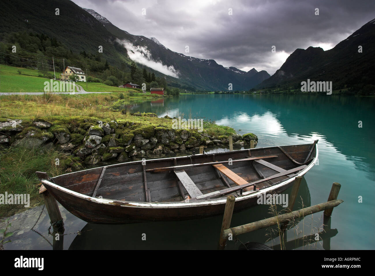Eine norwegische Ruderboot liegt angebunden in den Spiegel wie türkisfarbenen Wasser des Sees Olden, Norwegen Stockfoto