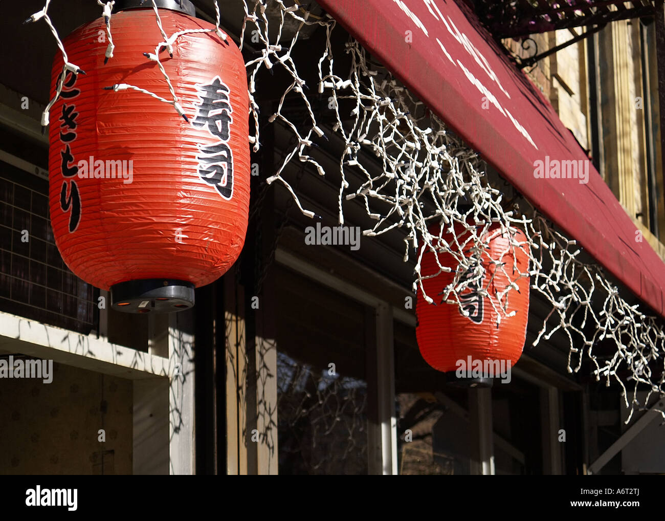 Verfallene Papierlaternen und Eiszapfen Lichter hängen unter einer Markise in New Yorks Chinatown. Stockfoto