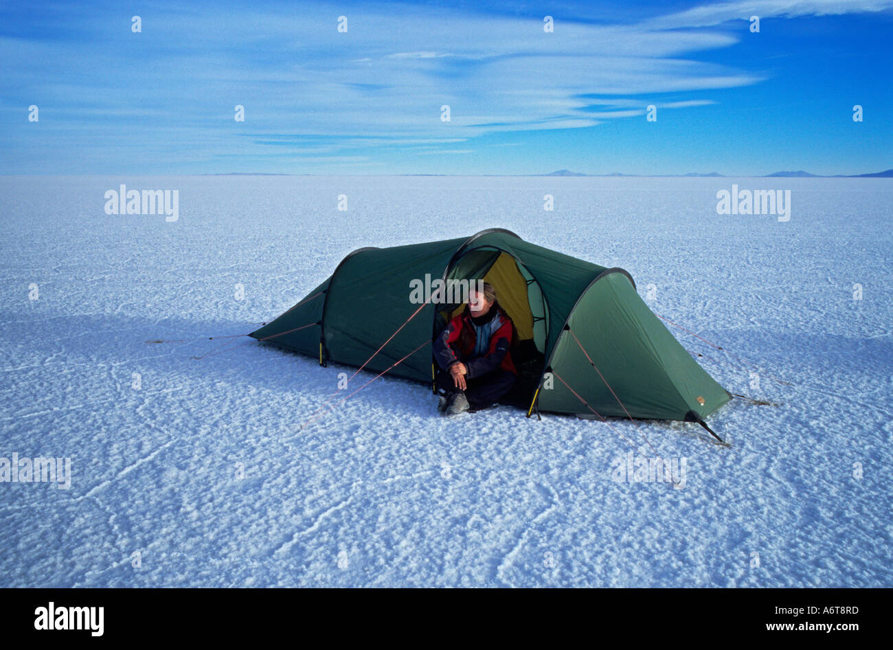 Frau allein im Zelt mit Weite des Salar de Uyuni Salz flach herum auf 3800 Metern Höhe in Bolivien Stockfoto