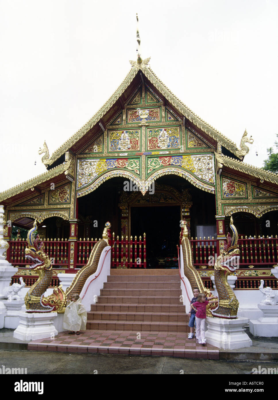 Westliche Kinder am Eingang zu einem Wat oder Tempel Chiang Saen Thailand Stockfoto