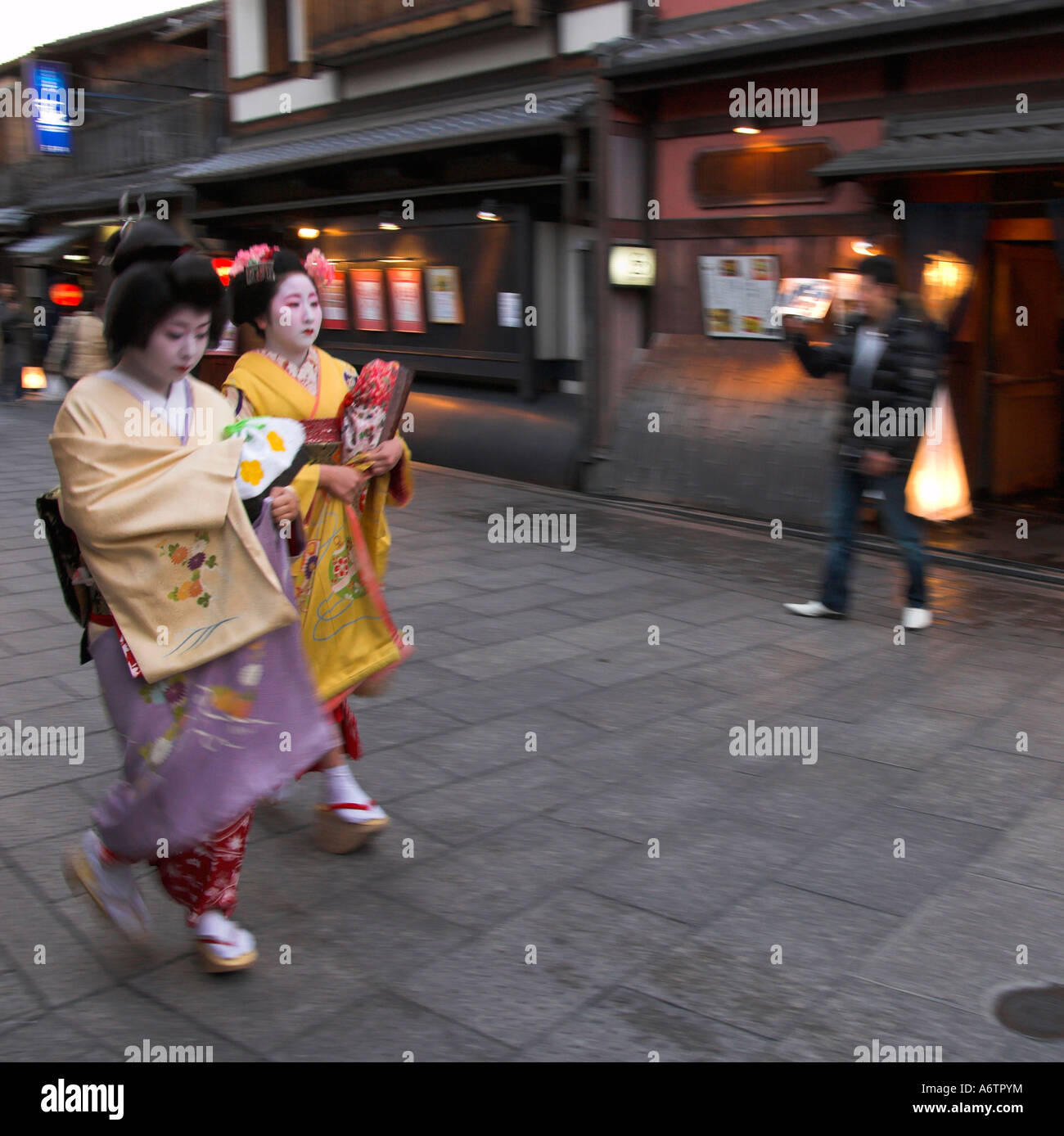 Japan zentralen Honshu Kansai Kyoto Gion Stadtteil Gion Corner zwei Geishas im traditionellen Kleid zu Fuß in der Abenddämmerung zu ihren headq Stockfoto