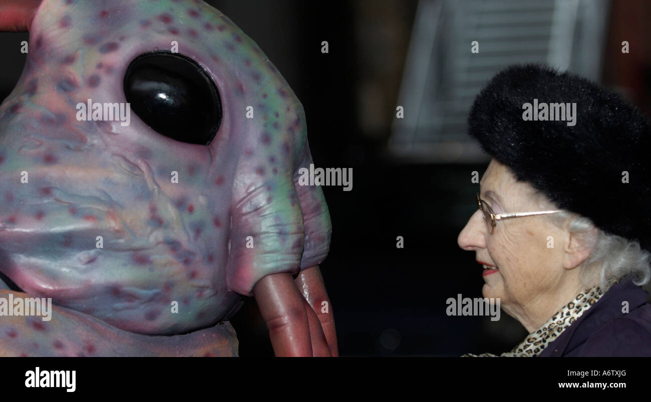 Ältere Dame im Gespräch mit einem außerirdischen monster Stockfoto