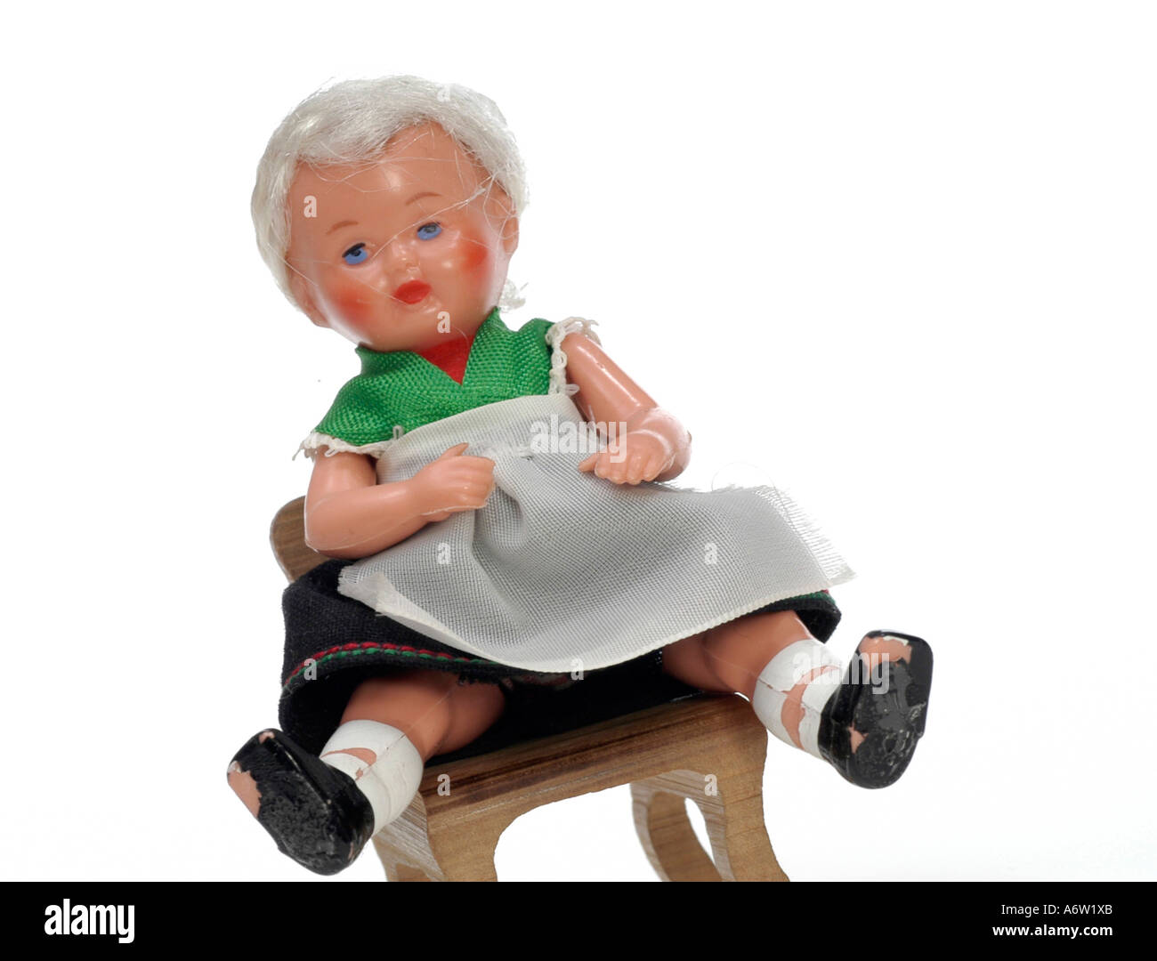 Puppe, Mädchen im Dirndl auf einem Stuhl Stockfoto