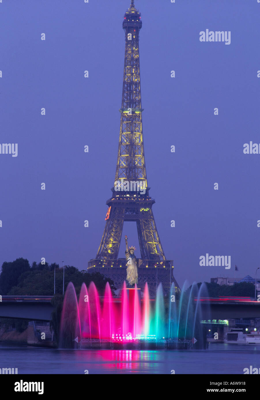 Frankreich Paris XV Eiffelturm und Freiheitsstatue leuchtet in der Dämmerung mit Seineufer und beleuchteten Brunnen in frgd Stockfoto