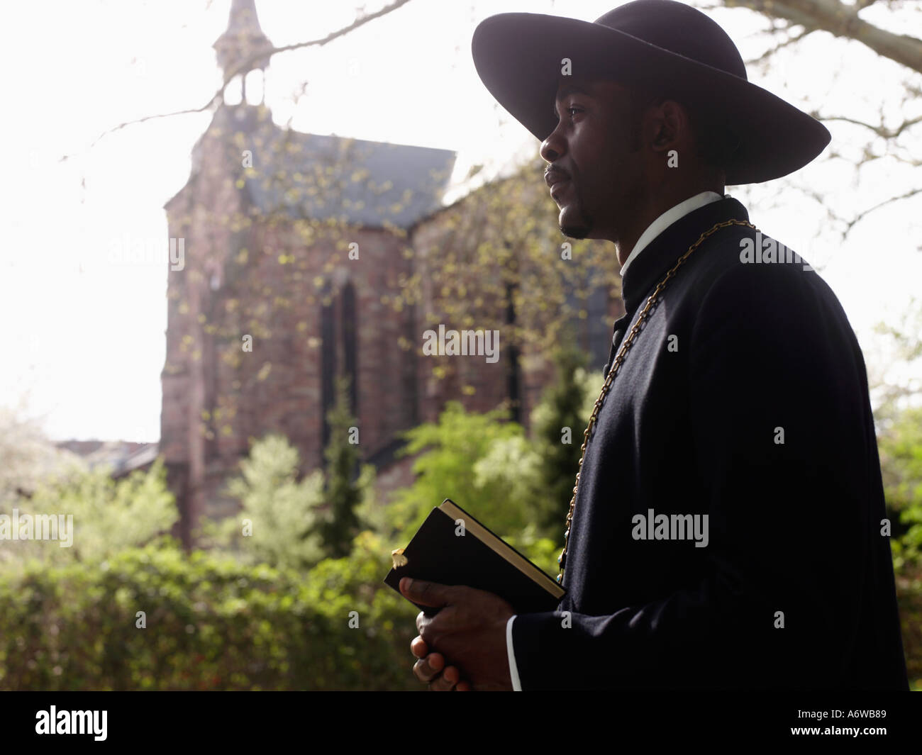 Afrikanischer Priester Holding Bibel Stockfoto