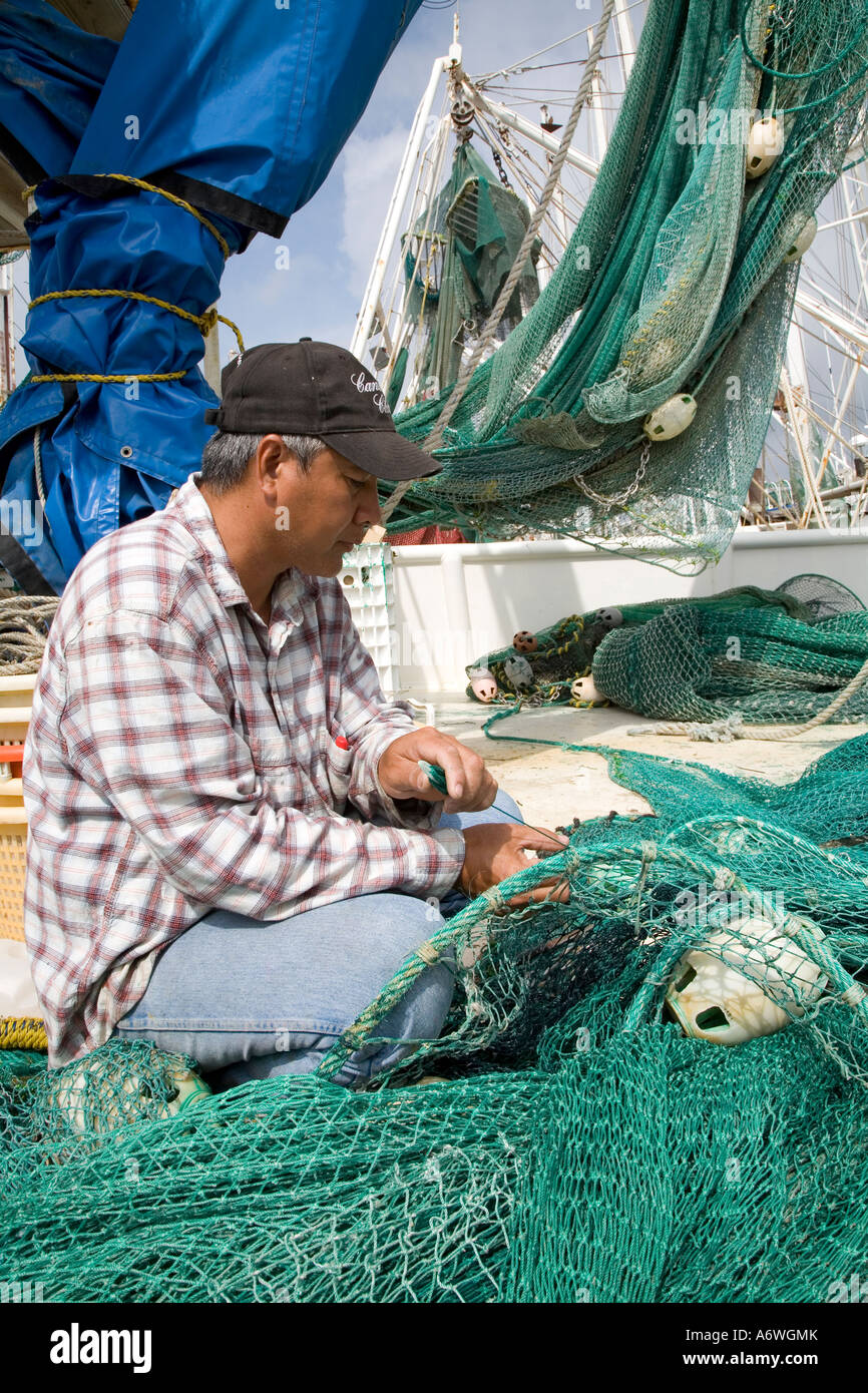 Vietnamesische Krabbenfischer in Mississippi reparieren Netze Stockfoto