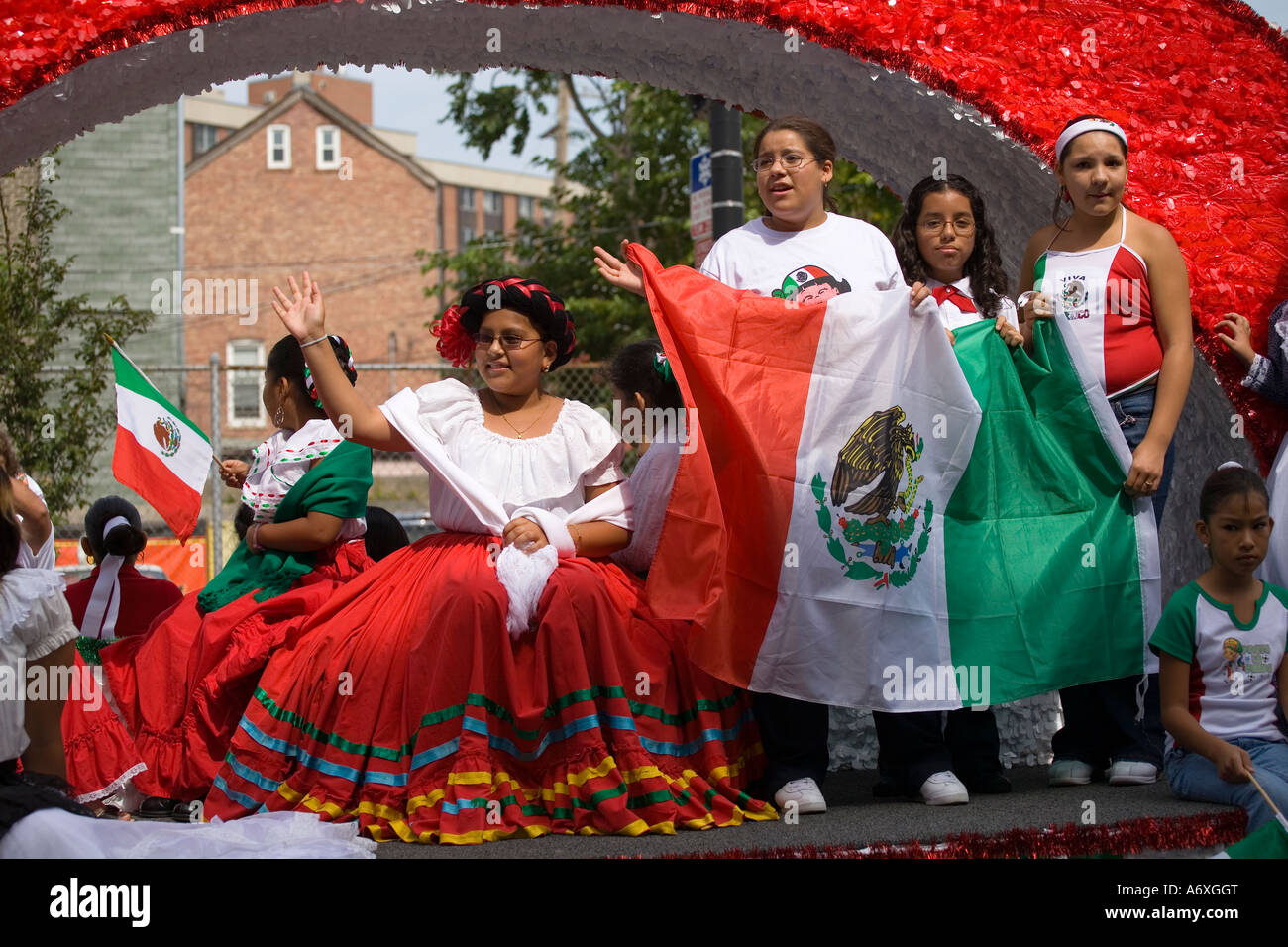 ILLINOIS-Chicago-Mädchen halten Flaggen Fahrt dekorierten Schwimmer im mexikanischen Unabhängigkeitstag Parade 18th Street Stockfoto