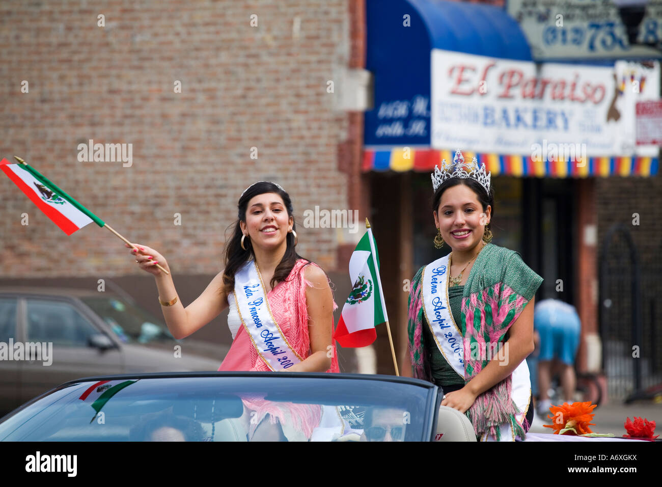 ILLINOIS-Chicago-zwei Girls Reiten Cabrio mexikanischen Independence Day-Parade in Pilsen Nachbarschaft halten mexikanische Flaggen Stockfoto