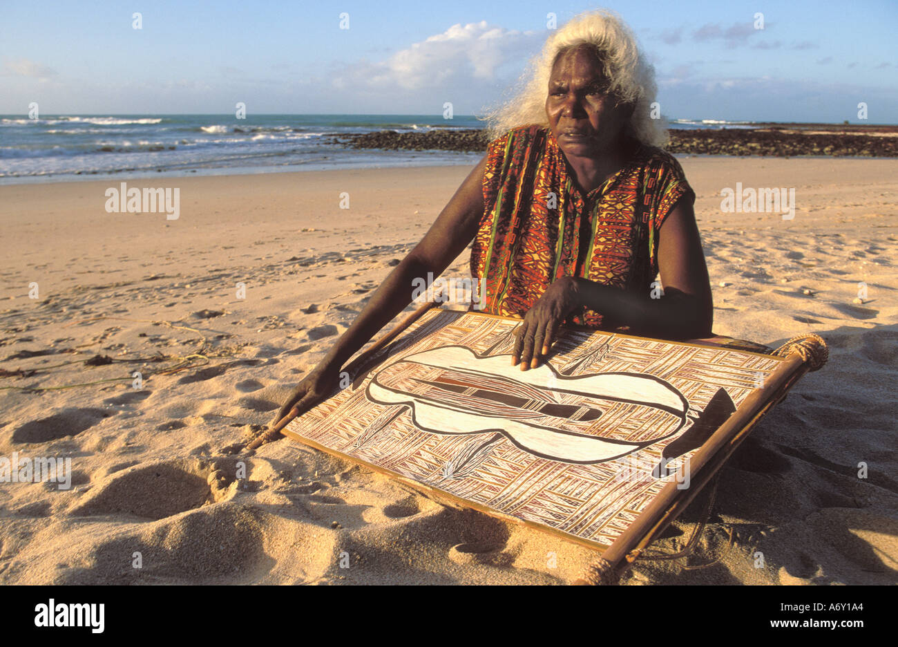 Dhuwarrwarr Marika Aborigine-Künstler am Yirrakala Strand mit eines ihrer Gemälde Stockfoto