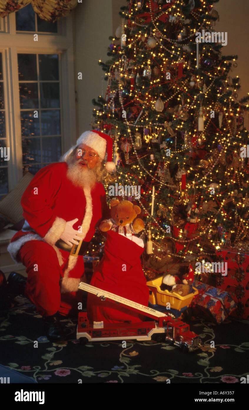 Santa Claus bringt Spielzeug unter dem Weihnachtsbaum erschrocken Stockfoto