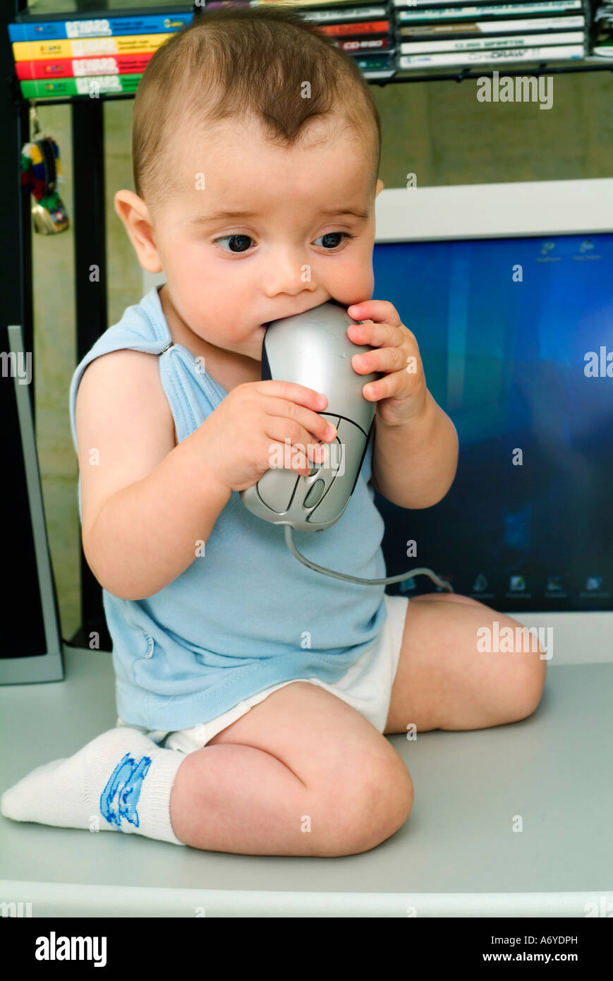 Baby Boy setzen Computer-Maus in den Mund Stockfoto
