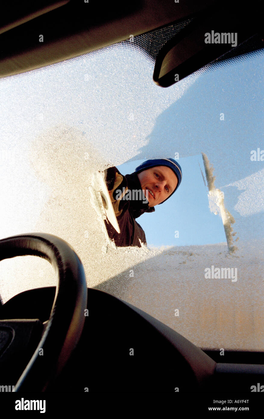 Mann auf der Suche durch Frost bedeckt Windschutzscheibe Stockfoto