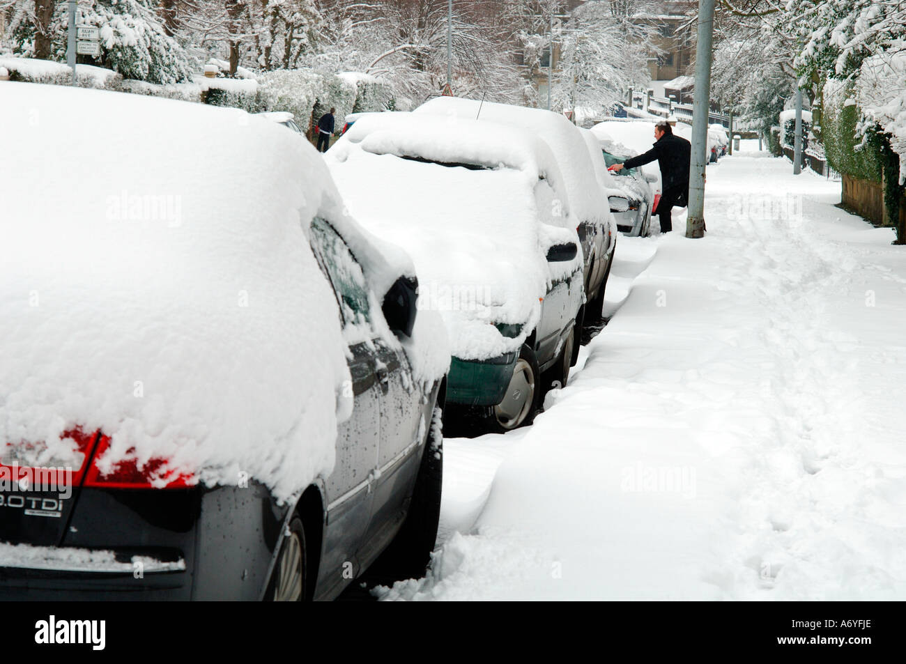 Autobesitzer, die versuchen, starken Schneefall aus seinem Auto zu löschen Stockfoto