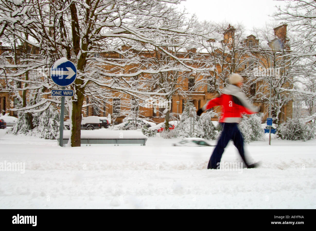 Frau mit roter Jacke Wandern in starkem Schneefall Stockfoto