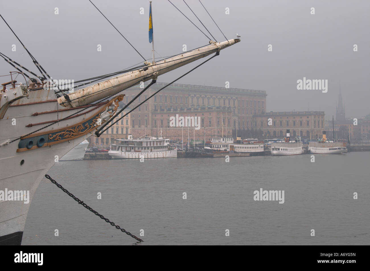 Dem schwedischen Königspalast in der Gamla Stan, die Altstadt. Der Bug des Schiffes Af Chapman im Vordergrund. Im nebligen Winterwetter Stockfoto