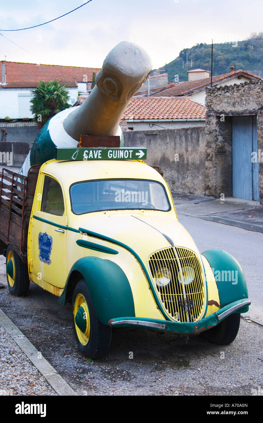 Guinot Höhle. Gelb und grün Oldtimer Peugeot 202 mit einer gigantischen Limoux Flasche dient als eine Werbung Werbung für das Weingut. Limoux. Languedoc. Frankreich. Europa. Flasche. Stockfoto