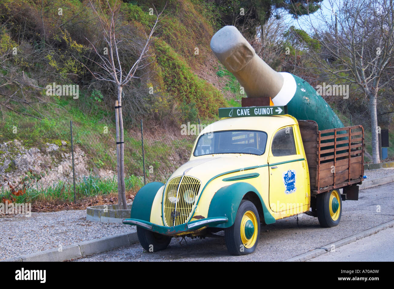 Guinot Höhle. Gelb und grün Oldtimer Peugeot 202 mit einer gigantischen Limoux Flasche dient als eine Werbung Werbung für das Weingut. Limoux. Languedoc. Frankreich. Europa. Stockfoto