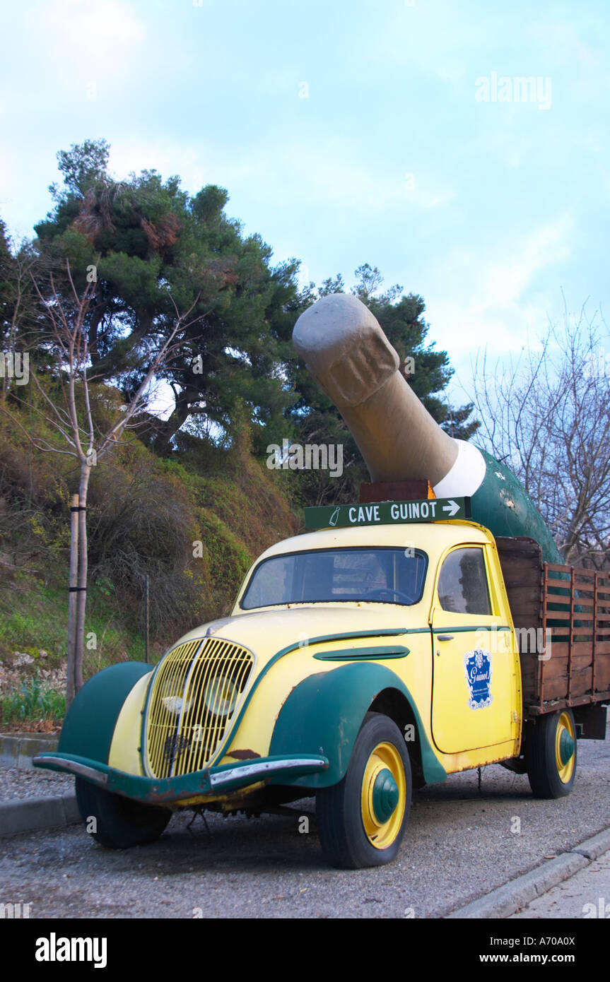 Guinot Höhle. Gelb und grün Oldtimer Peugeot 202 mit einer gigantischen Limoux Flasche dient als eine Werbung Werbung für das Weingut. Limoux. Languedoc. Frankreich. Europa. Stockfoto