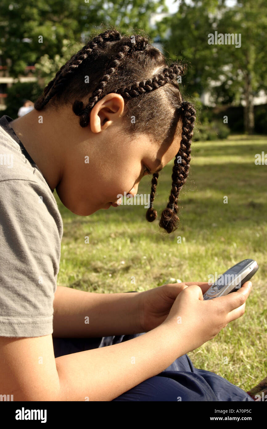 Vereinigte Königreich South London Brixton ein gemischtes Rennen junge spielt mit einem Mobiltelefon Stockfoto