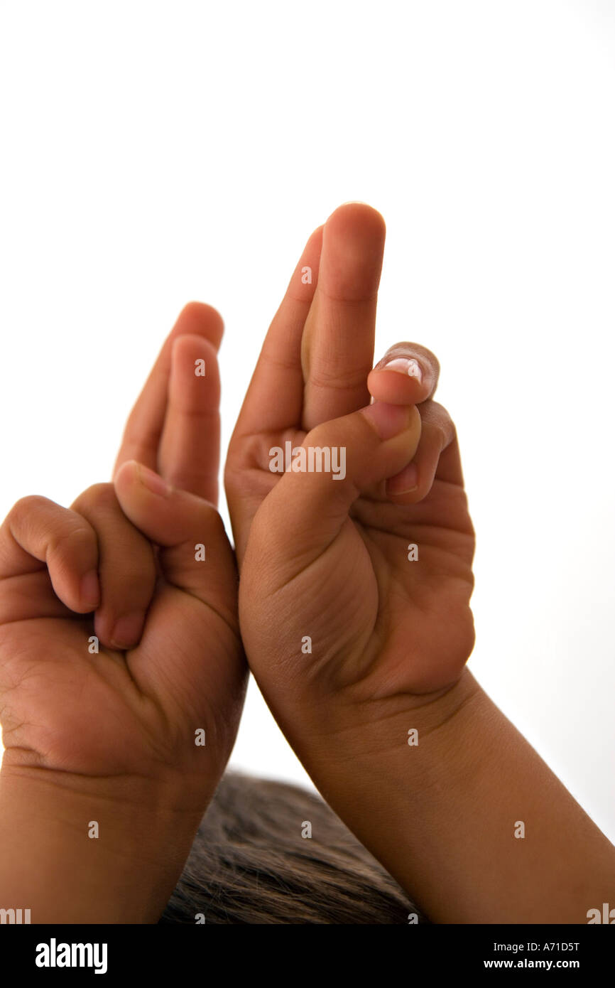 Jungen im Alter von fünf mit gekreuzten Fingern statt über Kopf Stockfoto