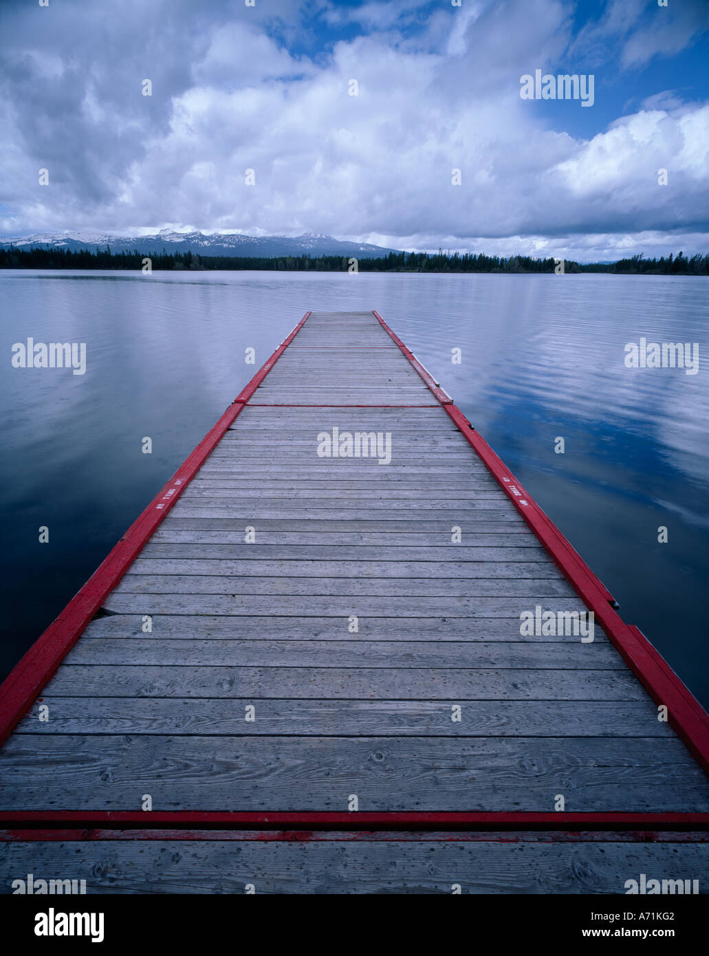 Rot umrandete Dock auf Insel-Park-See im östlichen Idaho erstreckt sich auf Frühling Wolken und Schnee bedeckte Gipfeln Stockfoto