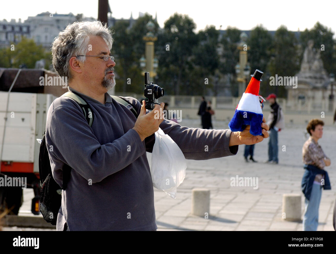 Männliche Touristen fotografieren von Paris mit Eiffelturm-Spielzeug Stockfoto