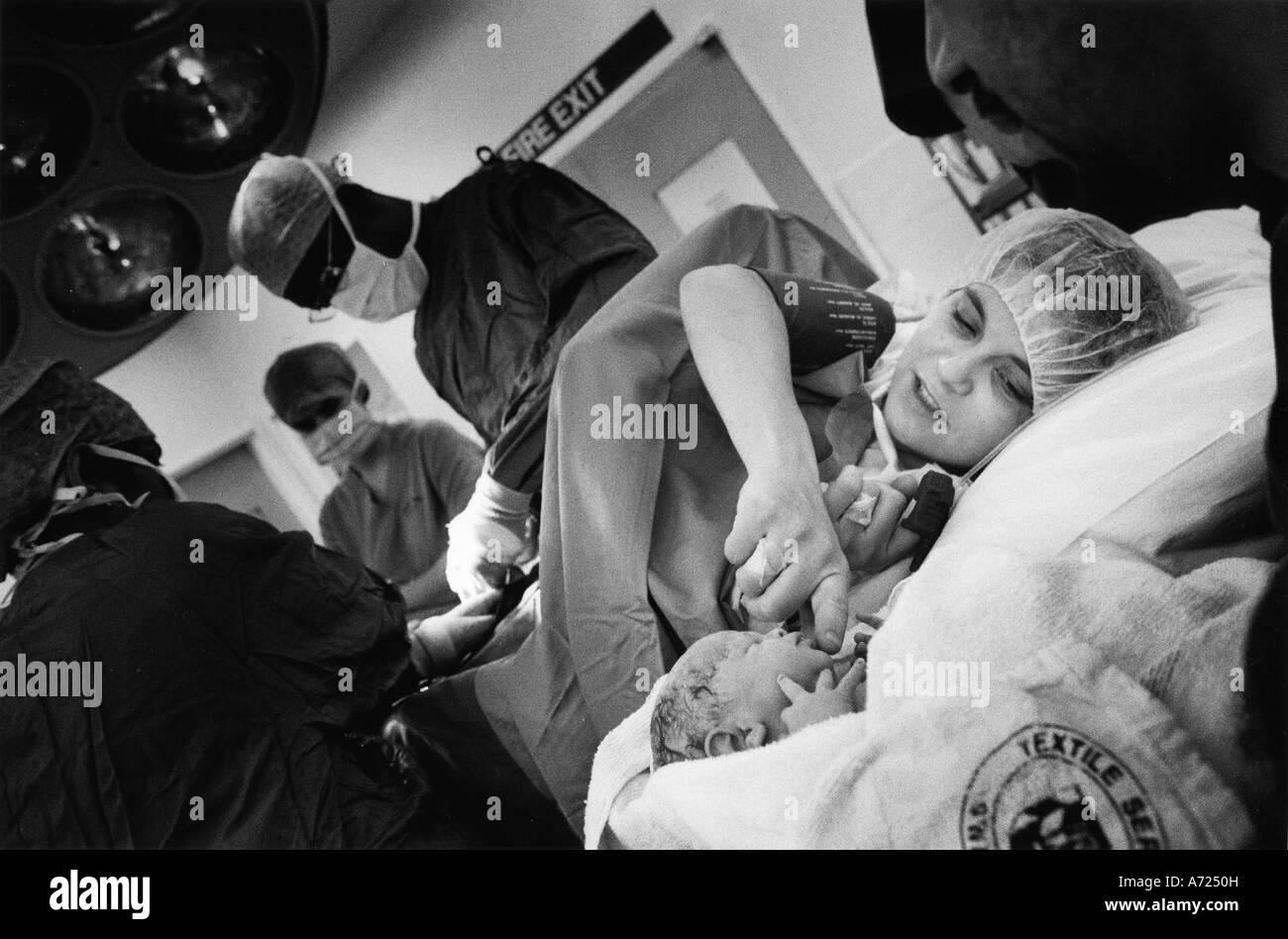 Donna streckt ihr Baby Sekunden nach seiner durch Kaiserschnitt Geburt zu berühren Stockfoto