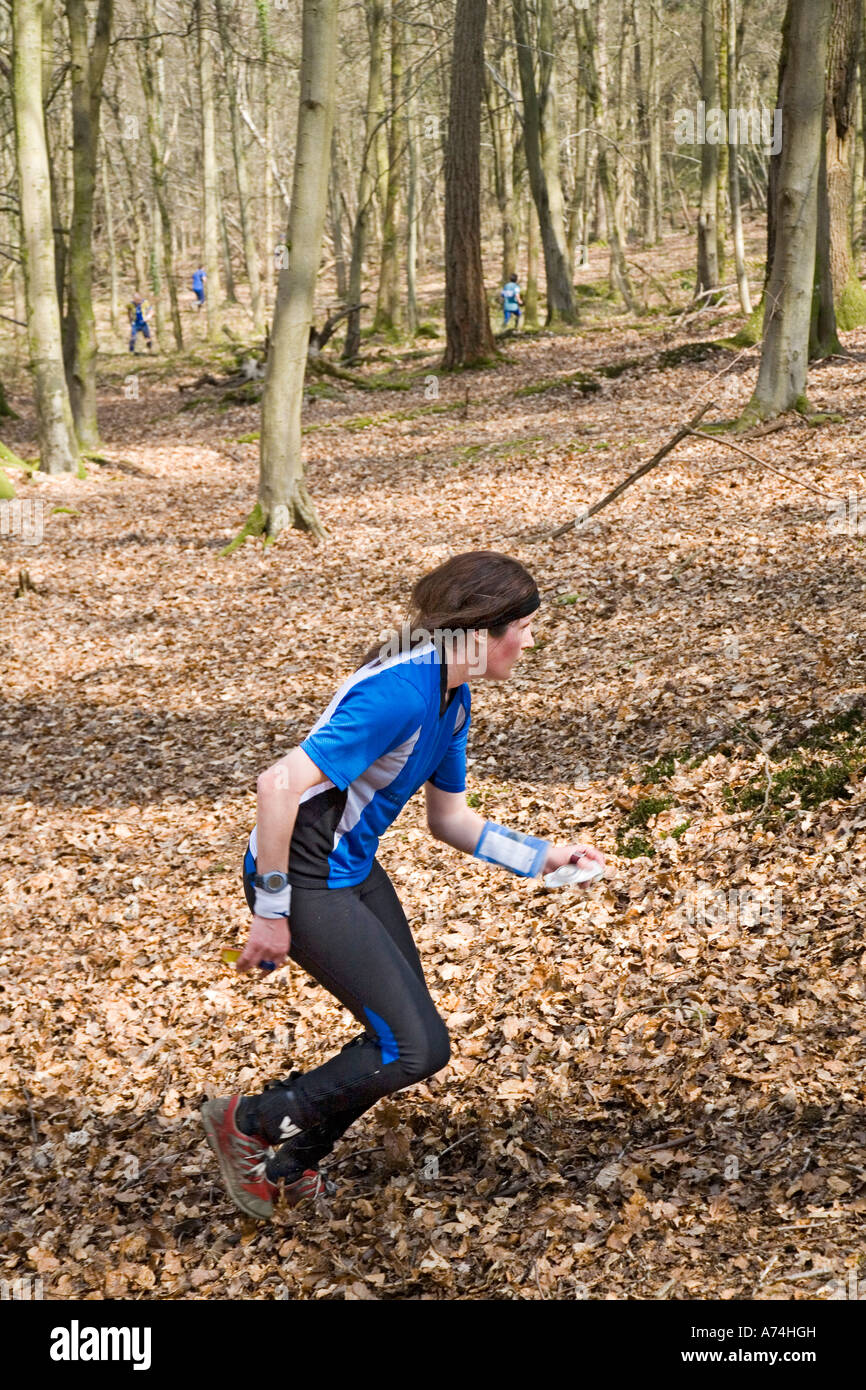 Mädchen laufen im Wald während OL mit anderen Konkurrenten in Ferne Forest of Dean UK Stockfoto