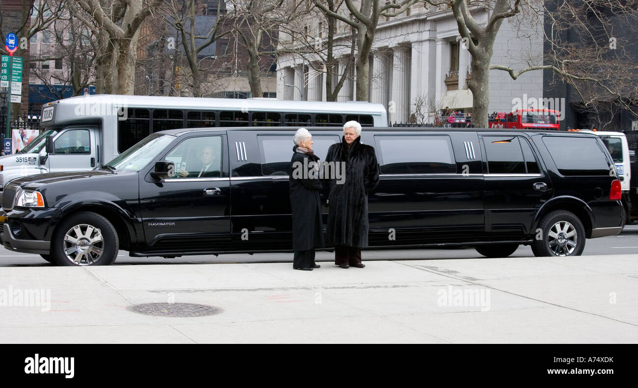 zwei Damen in Pelzmäntel mit stretch-Limousine engagiert im Gespräch Stockfoto