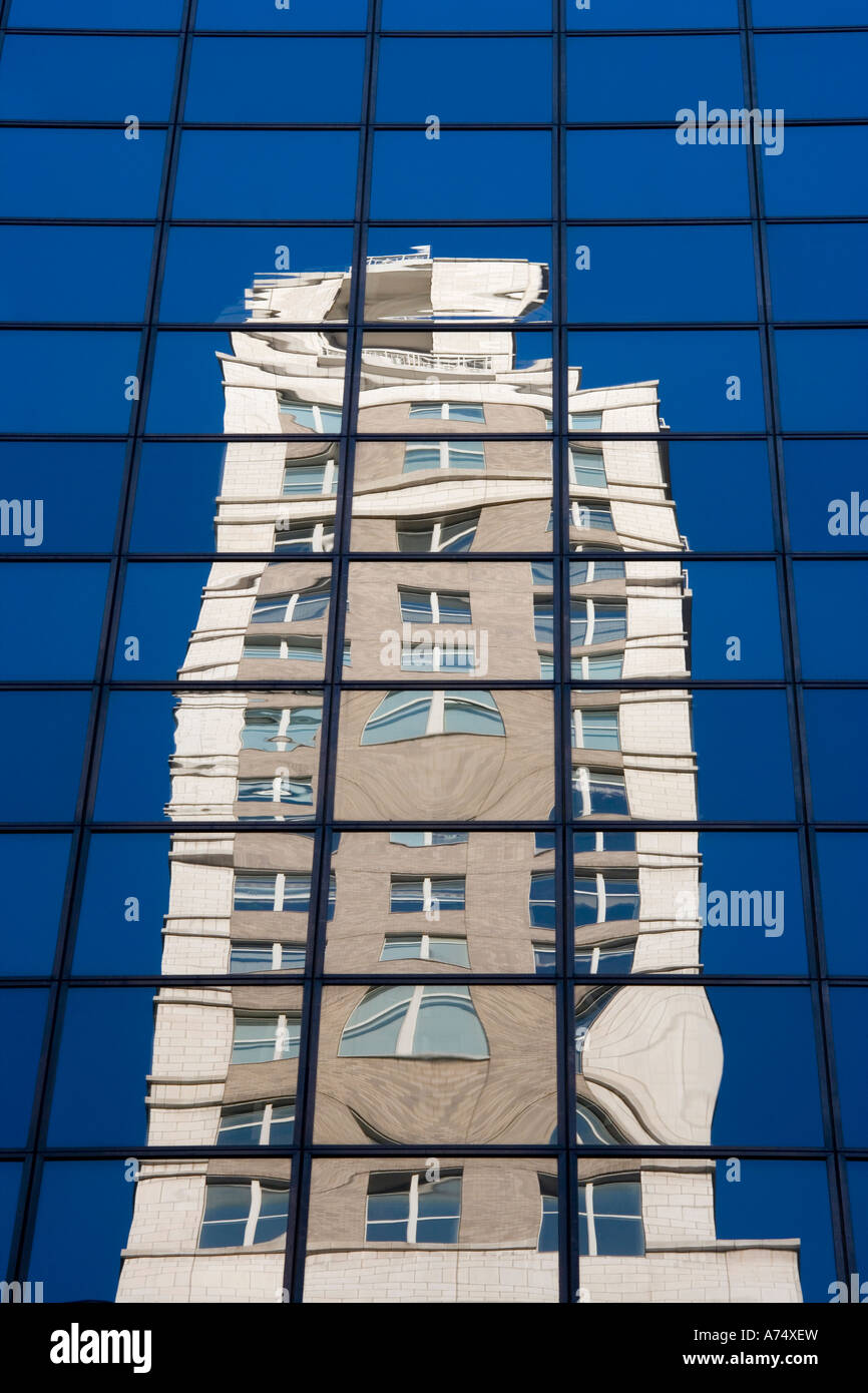 Reflexion des Gebäudes in Glasscheiben mit blauen Himmel im Hintergrund Stockfoto