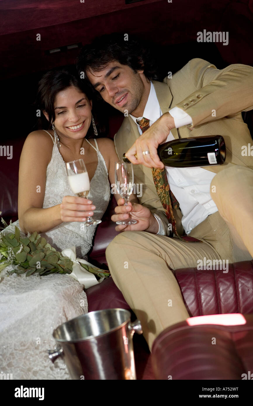 Brautpaar mit Champagner in limo Stockfoto