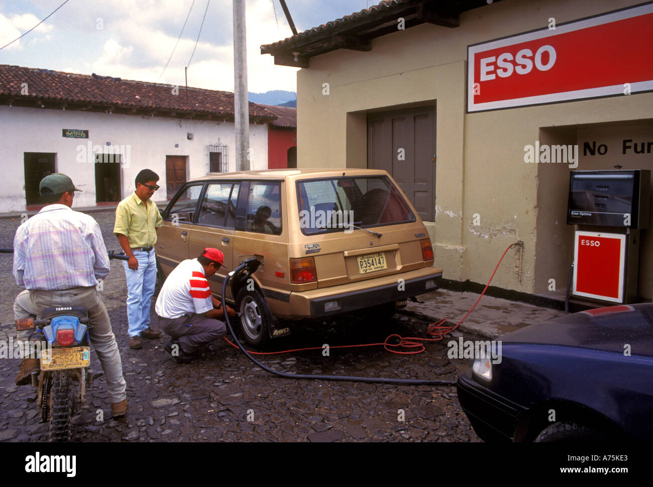 Guatemaltekische, Tankstellenwart, Reifendruck prüfen, Tankstelle mit vollem Serviceangebot, Esso Tankstelle, Antigua, Sacatepequez Department, Guatemala Stockfoto