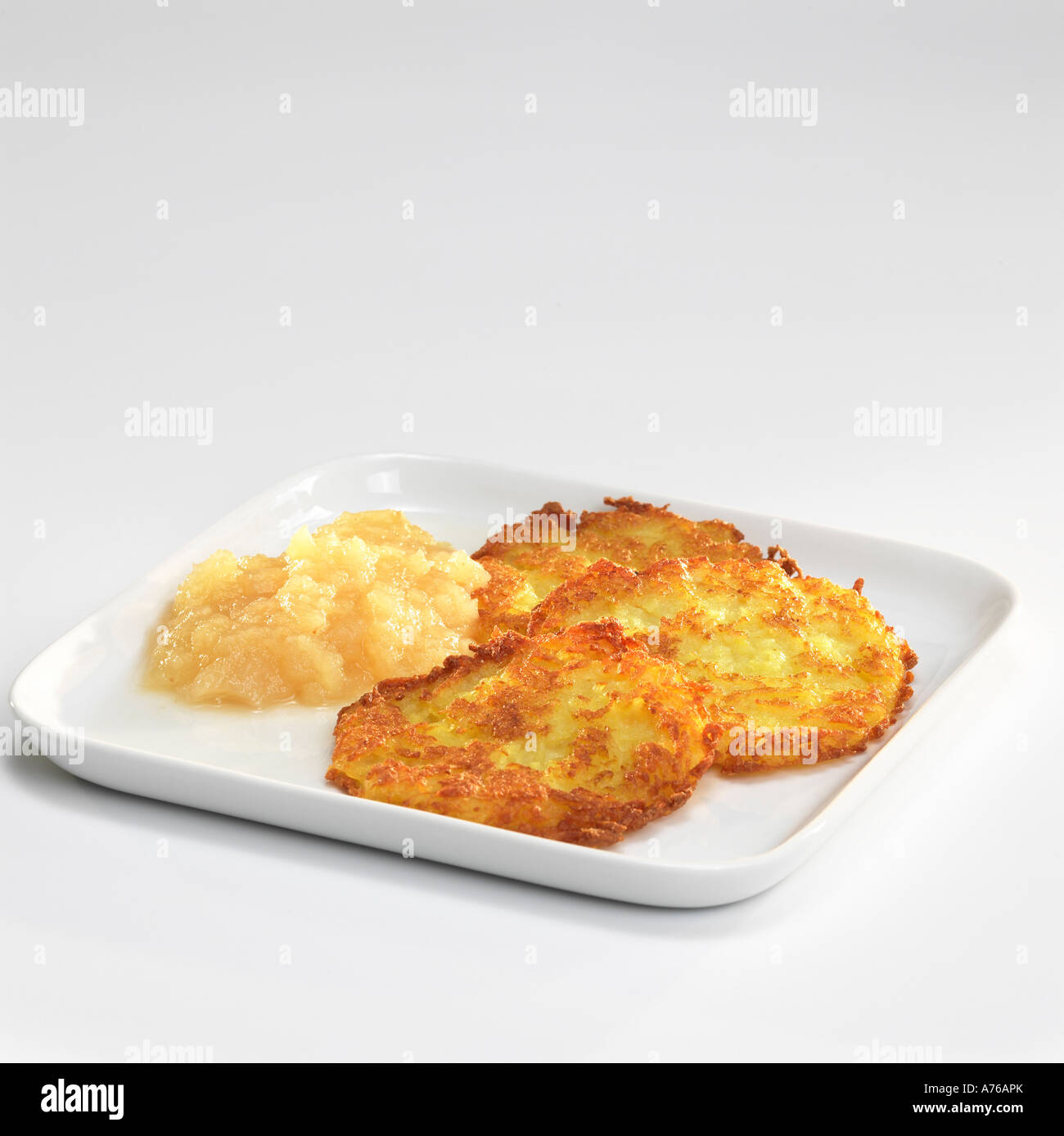 Kartoffel-Krapfen mit Apfel-Sauce auf Teller Stockfoto