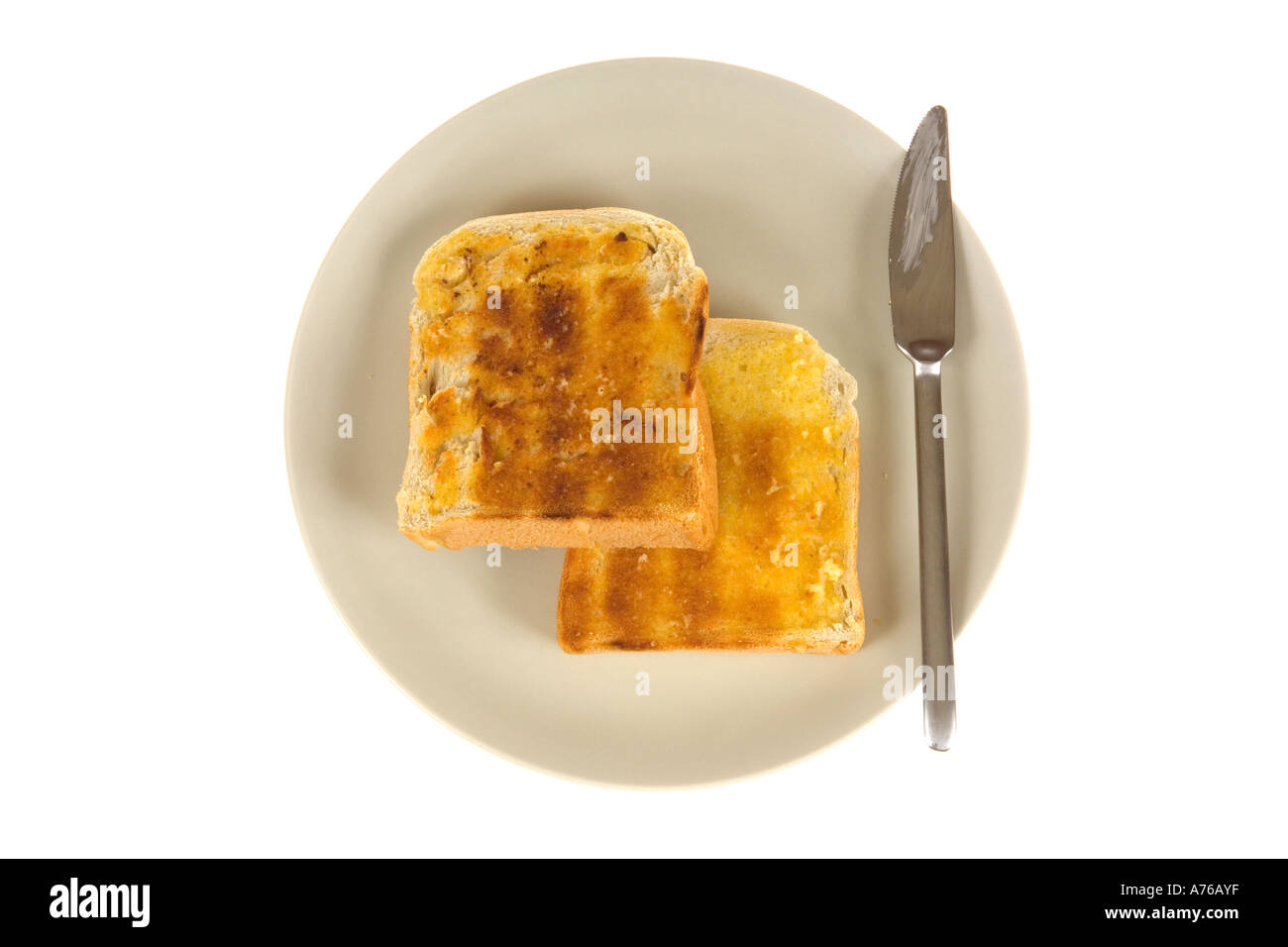 Zwei Scheiben heißen gebutterten Toast auf einem Teller mit einem Messer. Stockfoto