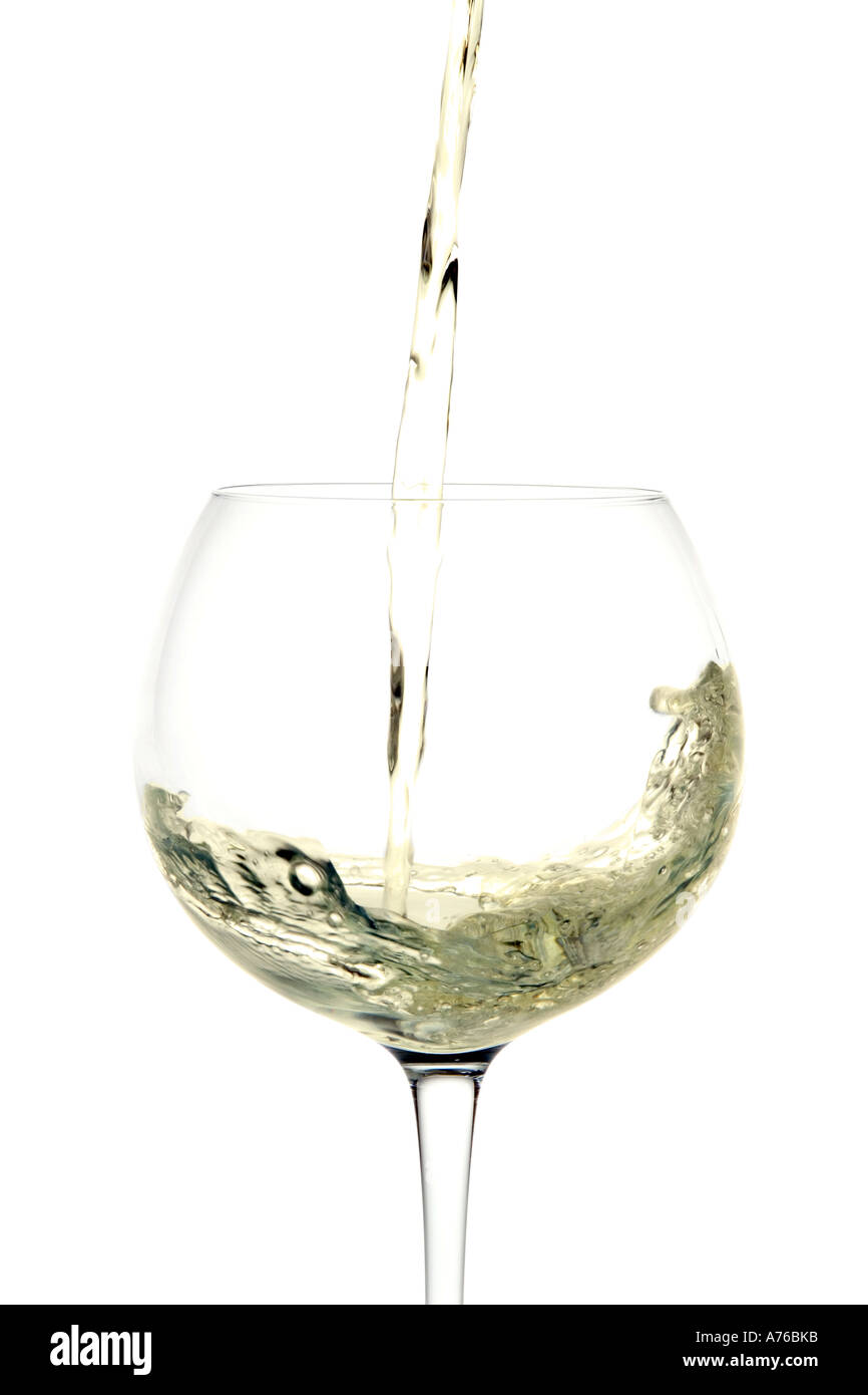 Weißwein auf einem reinen weißen Hintergrund in ein Glas gegossen wird. Stockfoto