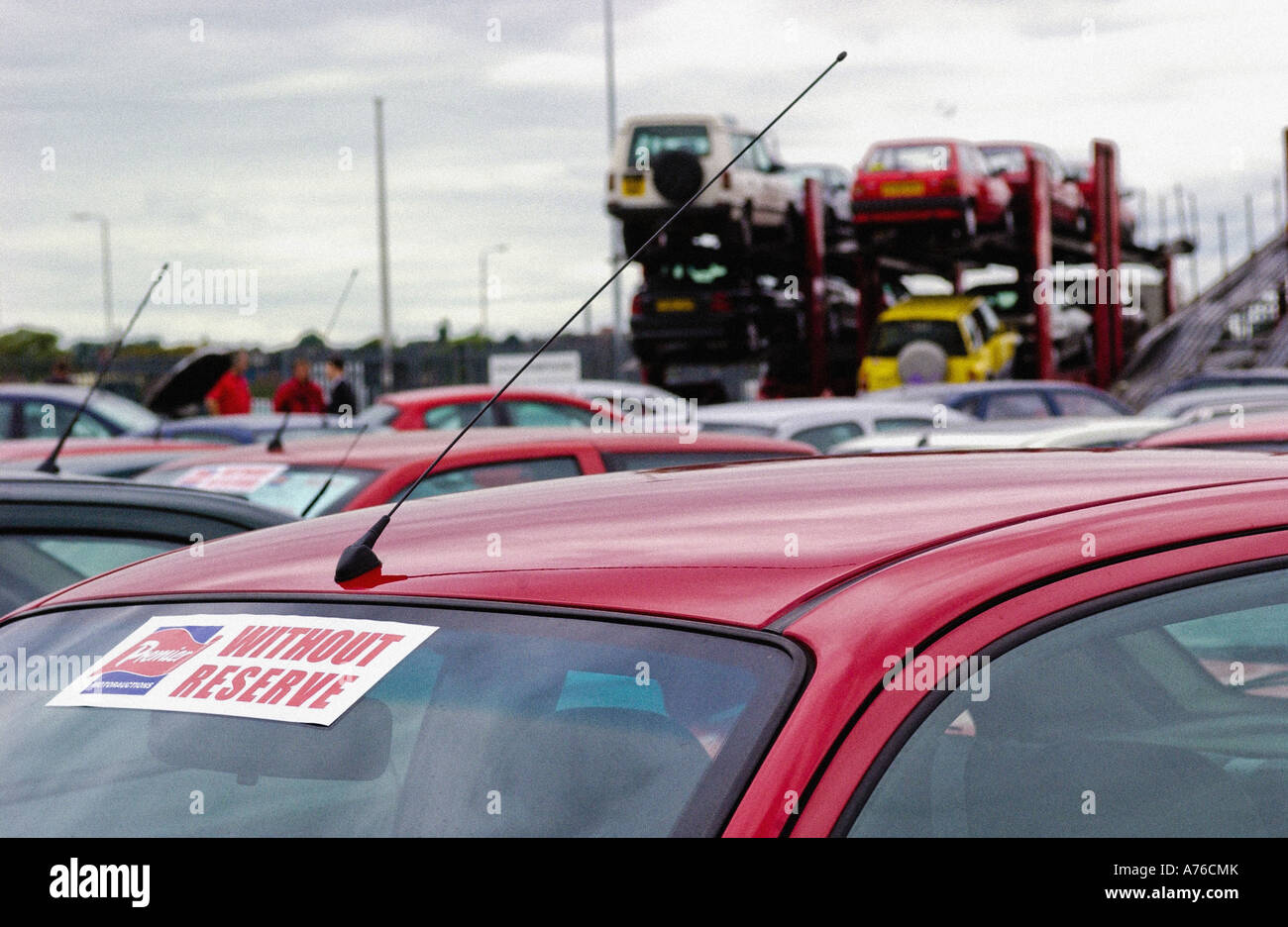 Auto bereit für Auktion mit einem Aufkleber ohne Reserve auf der Windschutzscheibe, gesehen mit Autotransportern im Hintergrund bei einer britischen Autoversteigerung. Stockfoto