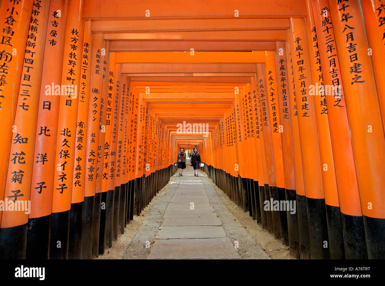 Orange lackiert Torii-Tore im Fushimi Inari-Taisha-Schrein in Kyoto Japan zwei Schulmädchen Stockfoto