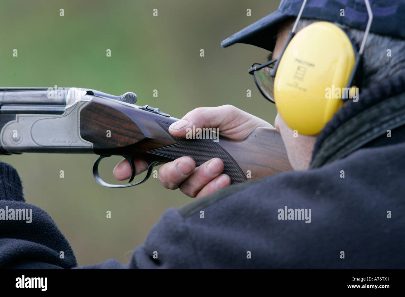 Mann in Baseball-Kappe tragen gelbe Ohr Verteidiger nimmt Ziel mit einer Schrotflinte Fabarm hautnah am Dezember Tag Grafschaft Antrim shooting Stockfoto